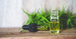 CBD olie werking flesje met druppelaar en hennepplant